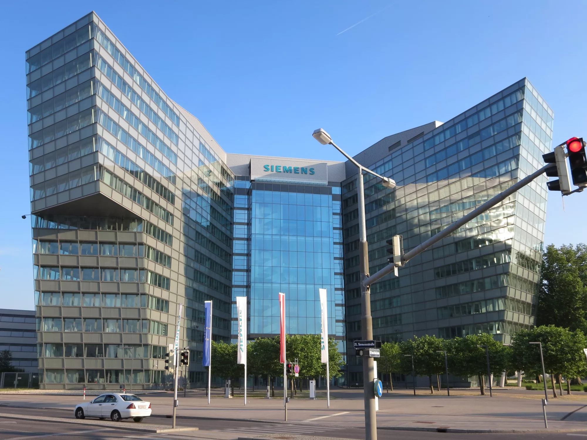 Siemens Bürokomplex mit geschwungener Glasfassade, verglastem Mitteltrakt und Schriftzug über dem Eingang.